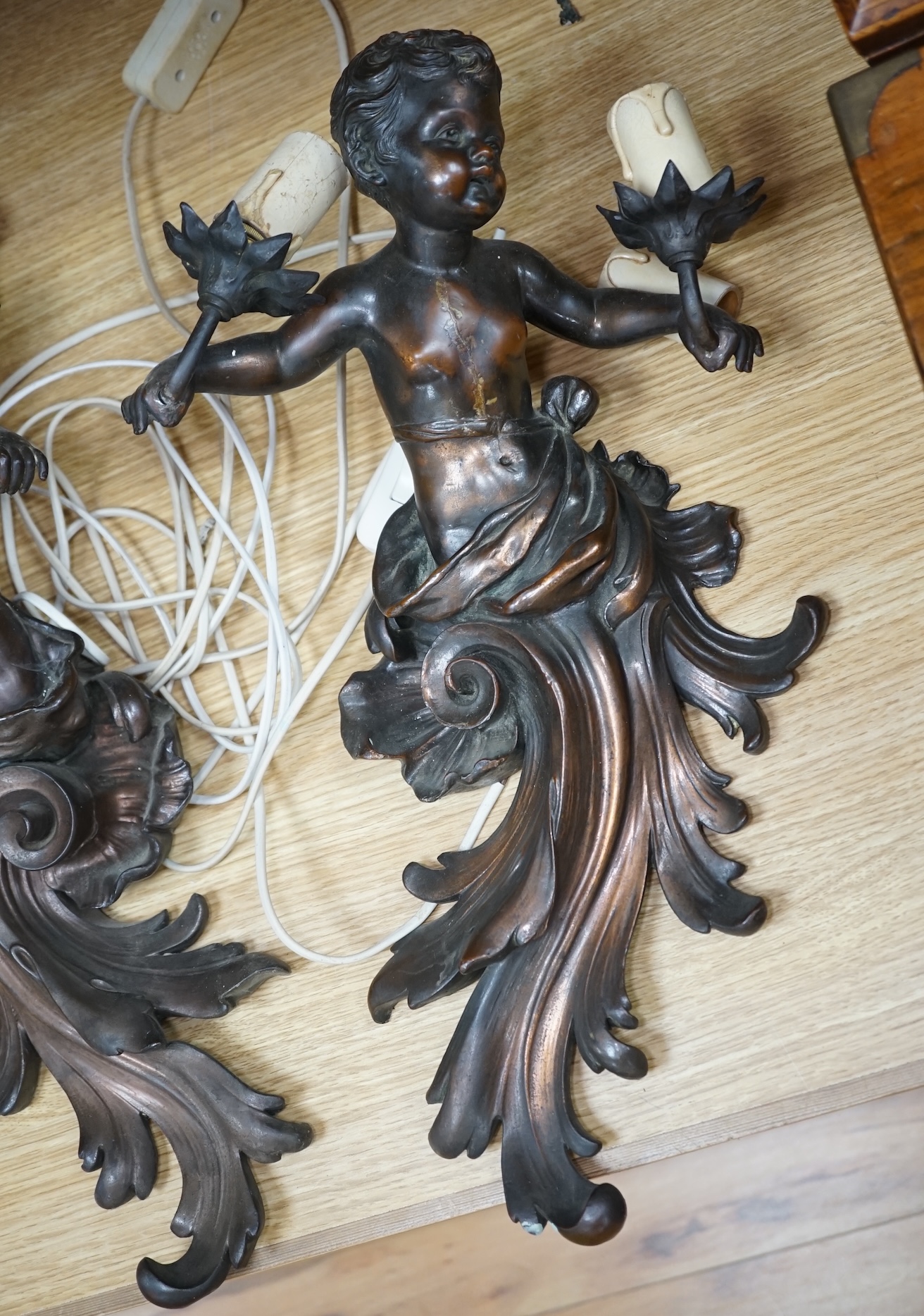 A pair of cast metal caryatid putti two light wall sconces, 45cm high. Condition - poor